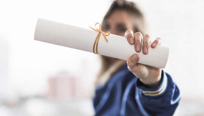 Photo stock d'une jeune femme montrant son diplôme.